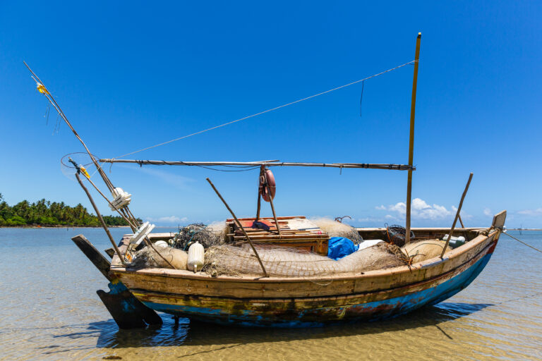Fishing boat at low tide on the beach in Boipeba Island, Brazil